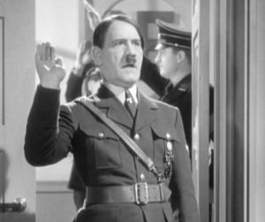 An actor (Tom Dugan) saying "Heil myself" as Hitler in a doomed production.
